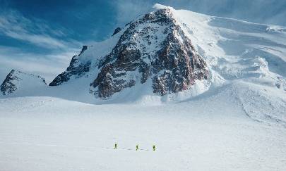 Mountain Climbers walk on a snowy mountain.