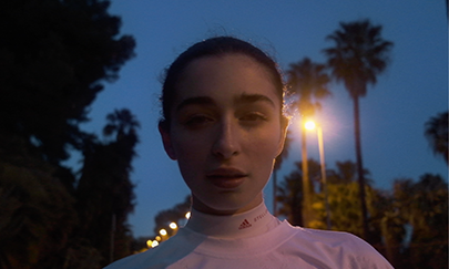 Luana Ruiz looks at the camera at night. A still from the Adidas and Tella McCartney Collaboration video 'Run'.